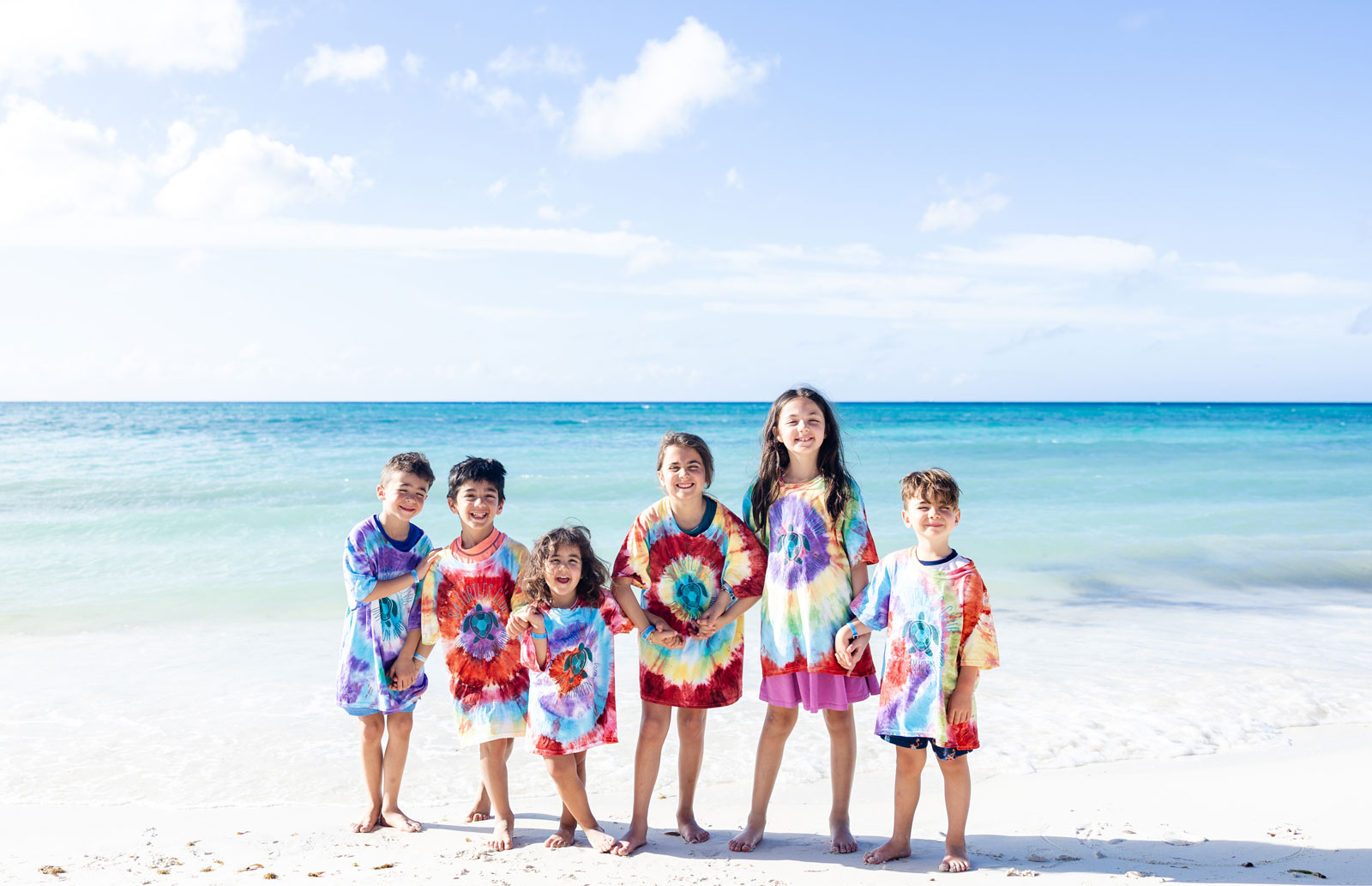 a group of kids posing for a picture on a beach