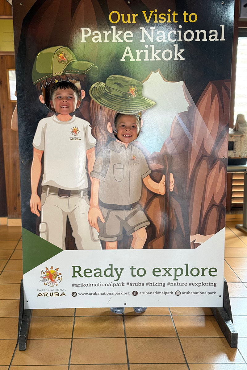 a boy smiling at a cardboard cutout of a boy