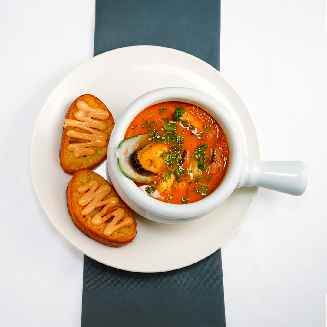 a bowl of soup and toast on a plate