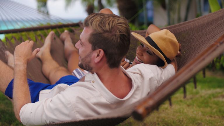 Couple enjoying the hammocks by the beach at Divi Aruba All Inclusive.