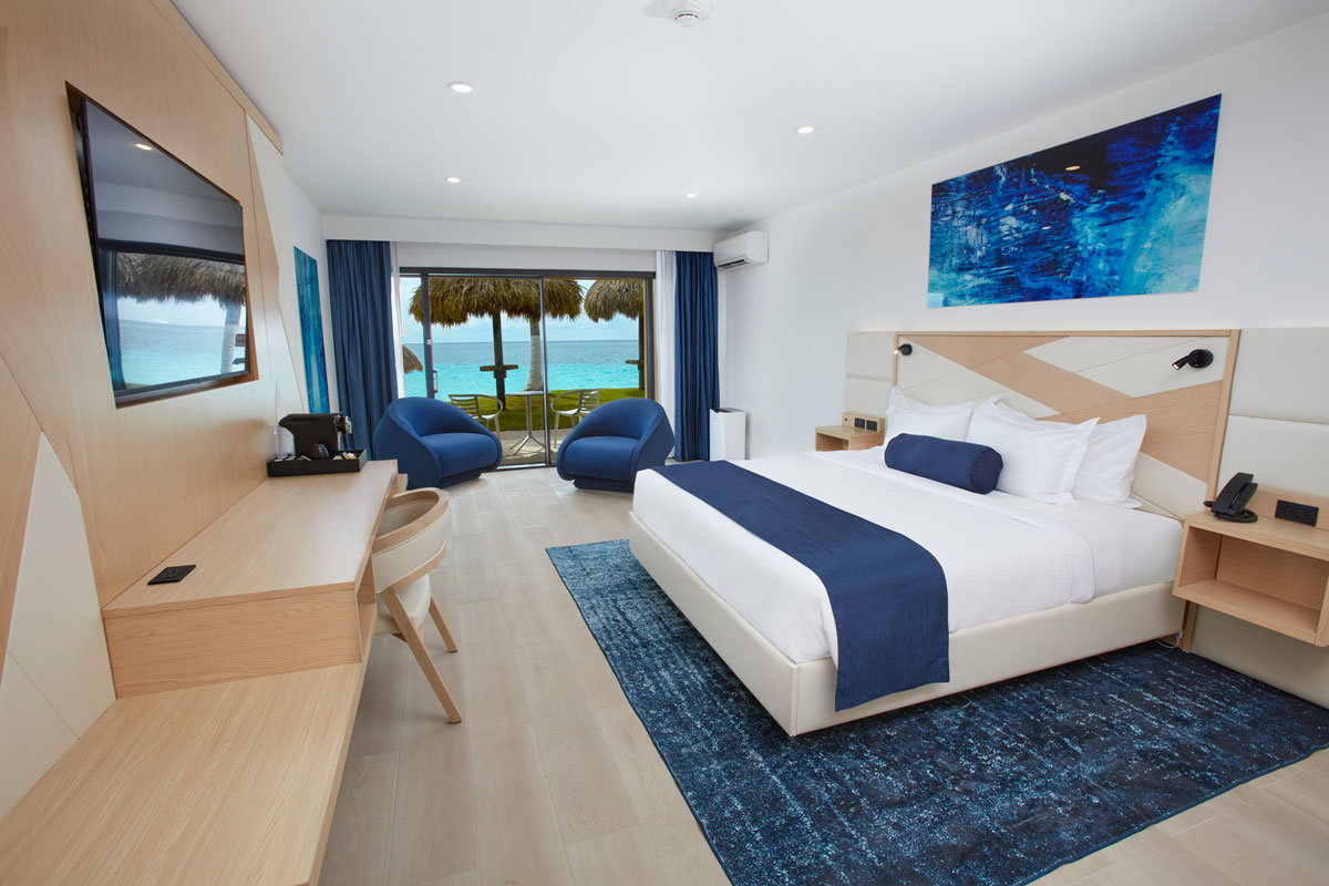 a room with a bed and chairs and a desk